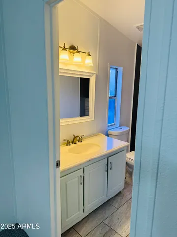 a bathroom with a granite countertop sink and a mirror