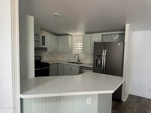 a kitchen with stainless steel appliances a refrigerator a sink a stove a microwave and island
