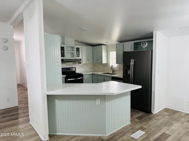 a kitchen with stainless steel appliances granite countertop a refrigerator a stove and a refrigerator with wooden floor