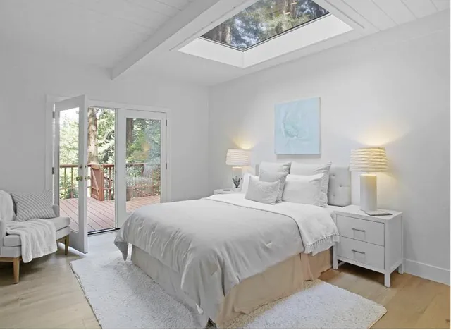 a bedroom with a bed and large windows