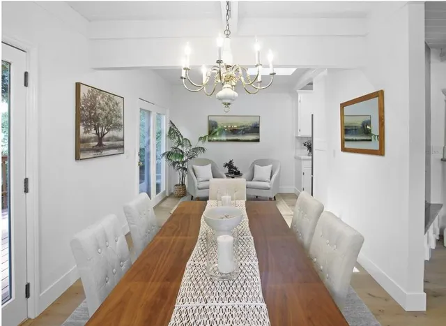 a view of a dining room with furniture a chandelier and wooden floor