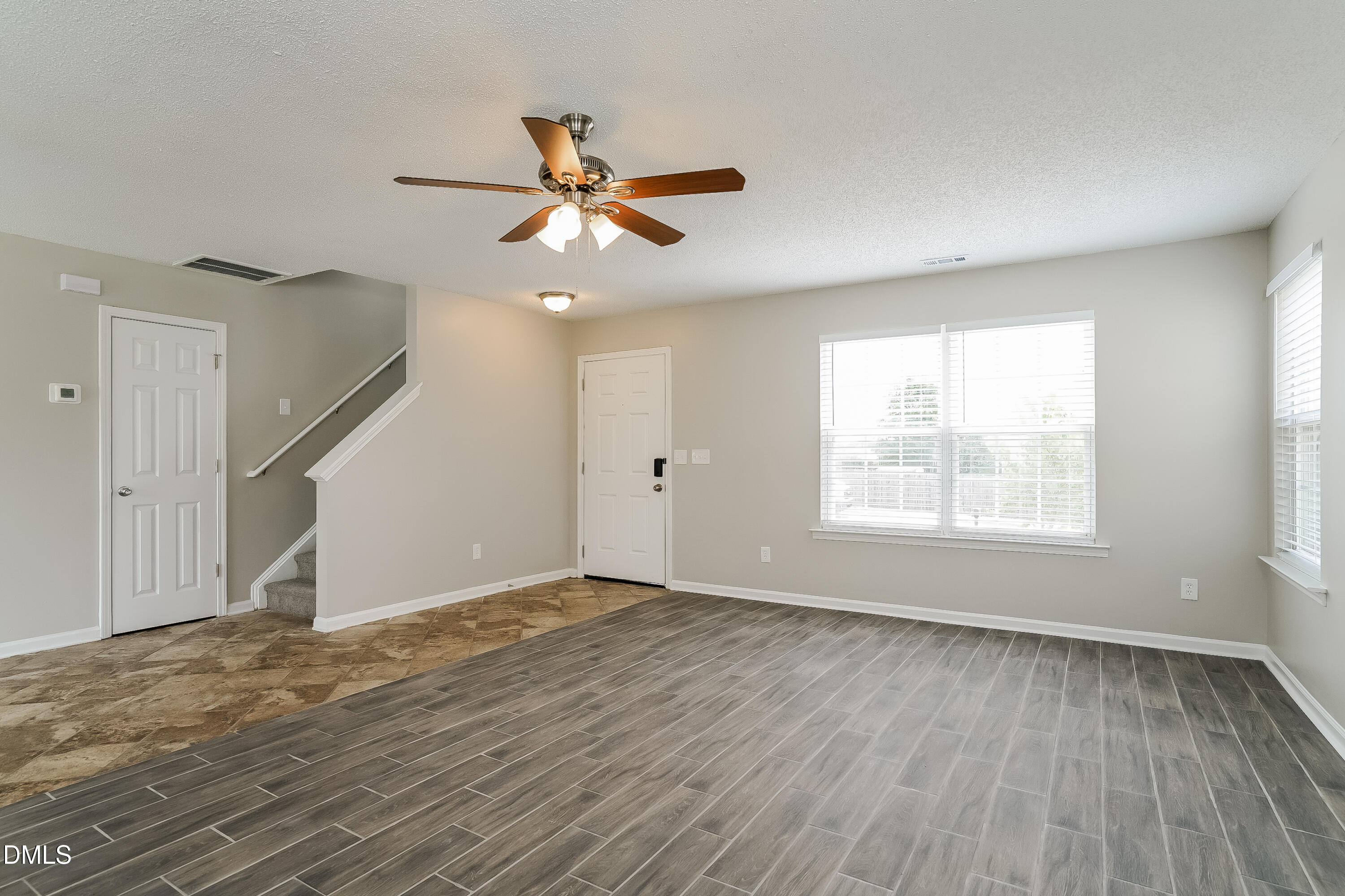 5924 Roteny Court Raleigh, NC 27610 - Photo 2 of 17 a view of an empty room with wooden floor and a window