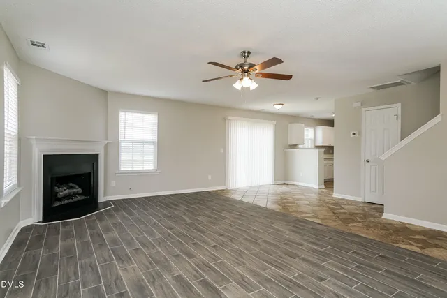 a view of empty room with wooden floor and fireplace