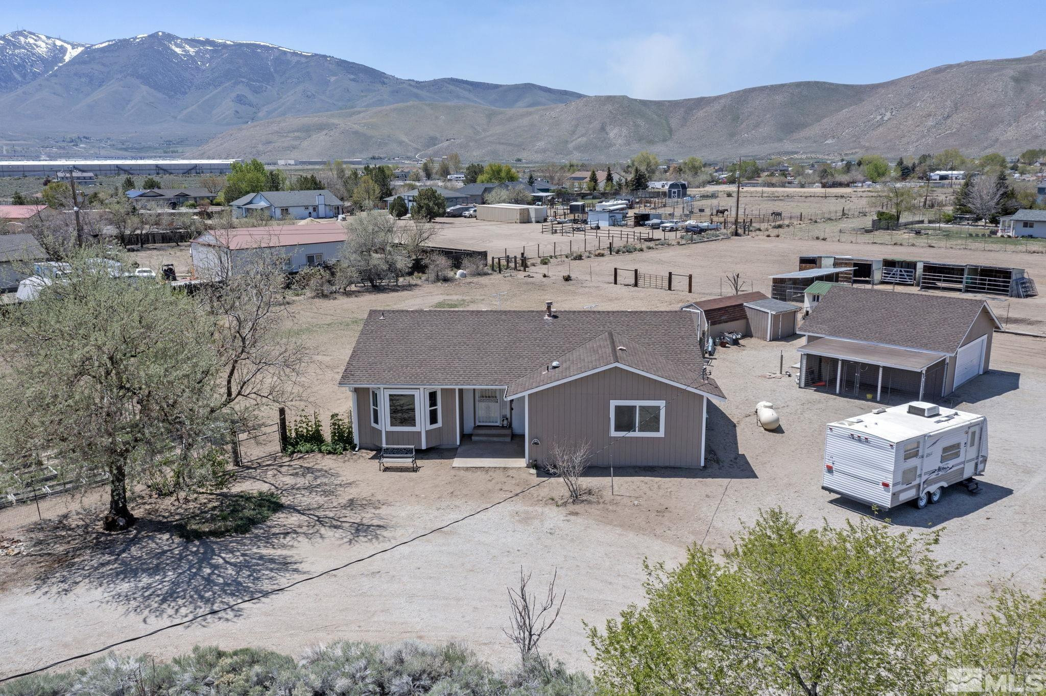 an aerial view of a house with a mountain