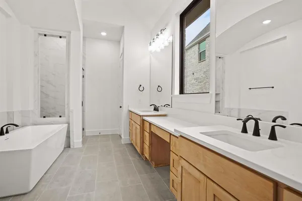a spacious bathroom with a bathtub sink double and mirror