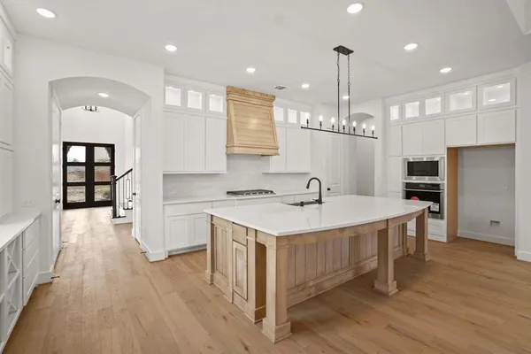 a kitchen with kitchen island a sink stove and refrigerator