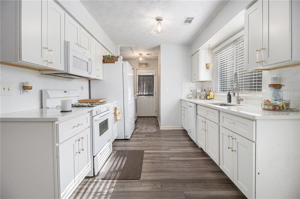 190 Kipling Way Riverdale, GA 30274 - Photo 7 of 22 a kitchen with white cabinets sink and white appliances