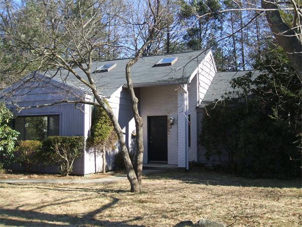 a view of a house with brick walls and a tree
