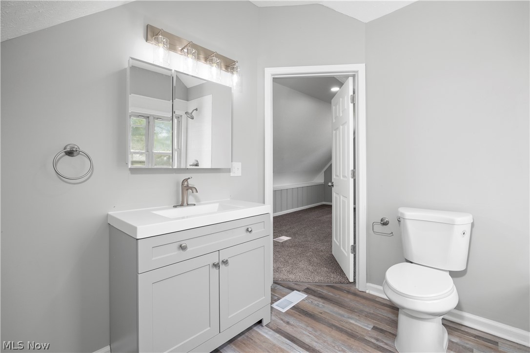 7030 Pearl Road Cleveland, OH 44130 - Photo 31 of 34 Bathroom featuring hardwood / wood-style flooring, toilet, and vanity with extensive cabinet space