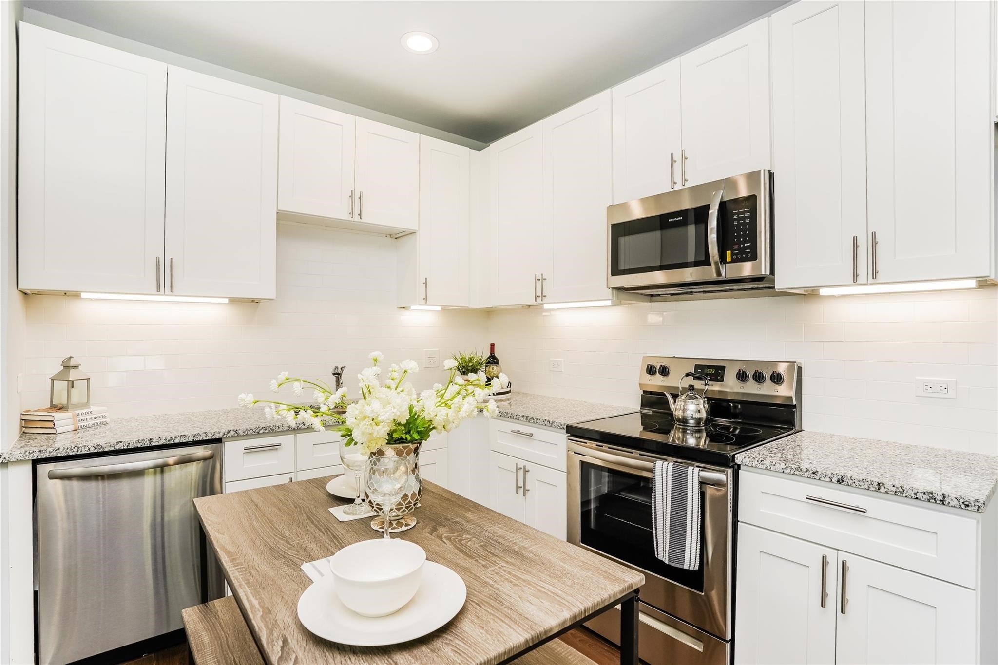 a kitchen with stainless steel appliances kitchen island granite countertop a sink a stove a microwave cabinets and a refrigerator