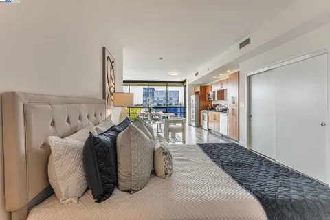 a bedroom with a large bed and a view of living room