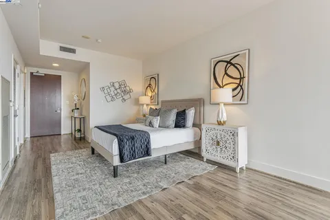 a spacious bedroom with a bed and wooden floor