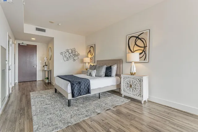 a spacious bedroom with a bed and wooden floor