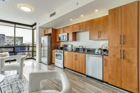 a kitchen with stainless steel appliances granite countertop a refrigerator a stove and a sink with cabinets