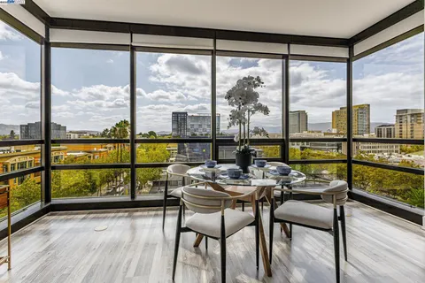 a view of a city from a dining room with furniture and window
