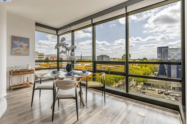 a view of a city from a dining room with furniture window and wooden floor