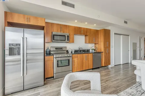 a kitchen with granite countertop a refrigerator and a stove top oven
