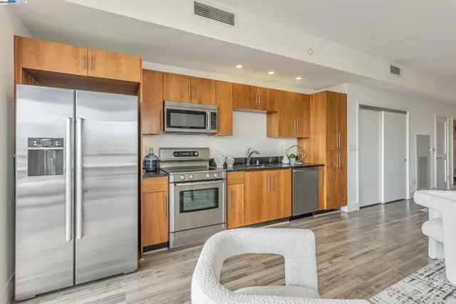 a kitchen with granite countertop a refrigerator and a stove top oven