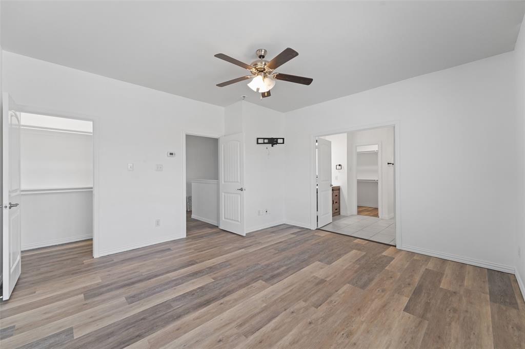 4651 Raleigh Dalton Road Dallas, TX 75227 - Photo 6 of 19 Wood-finish flooring, ceiling fan, white walls, and built-in closet shelving