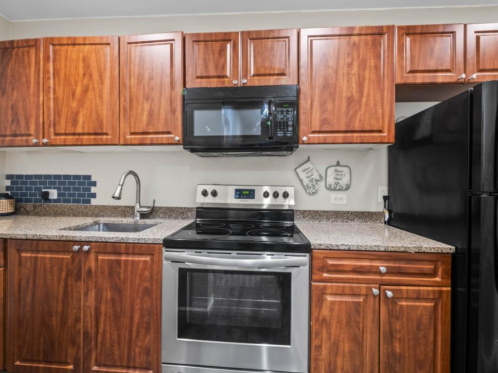 95 Ridge Water Lane Dawsonville, GA 30534 - Photo 40 of 45 a kitchen with granite countertop a stove top oven microwave and cabinets