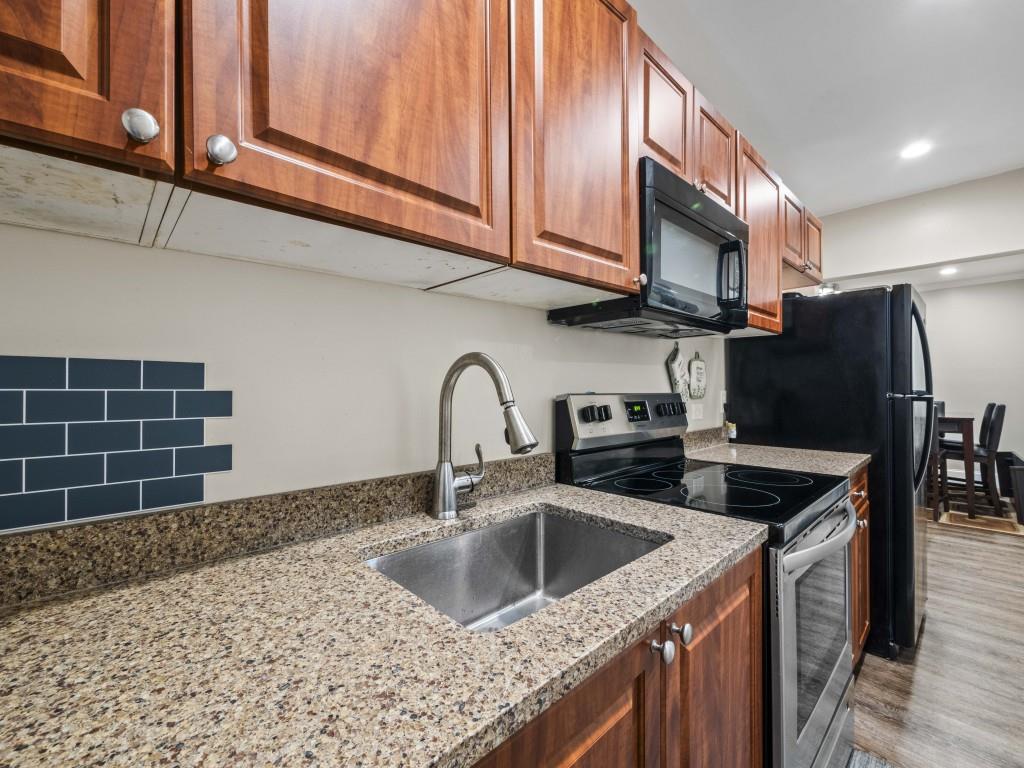 95 Ridge Water Lane Dawsonville, GA 30534 - Photo 41 of 45 a kitchen with stainless steel appliances granite countertop a sink a refrigerator and wooden cabinets