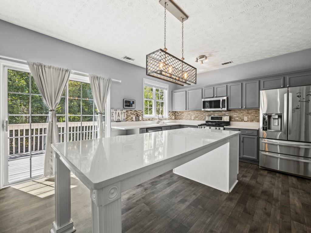95 Ridge Water Lane Dawsonville, GA 30534 - Photo 9 of 45 a kitchen with refrigerator cabinets and a chandelier