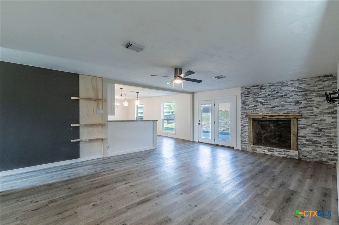 4013 Valley View Drive Temple, TX 76502 - Photo 2 of 25 an empty room with wooden floor fireplace and windows