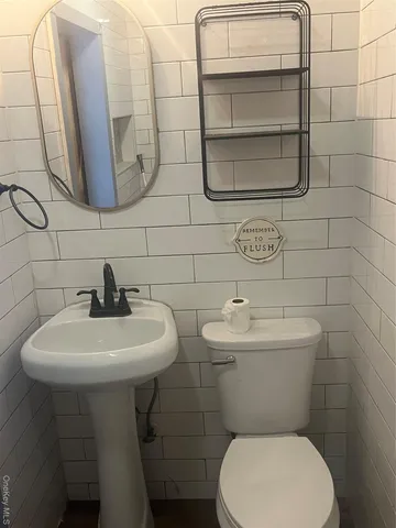 a bathroom with a sink a toilet and mirror