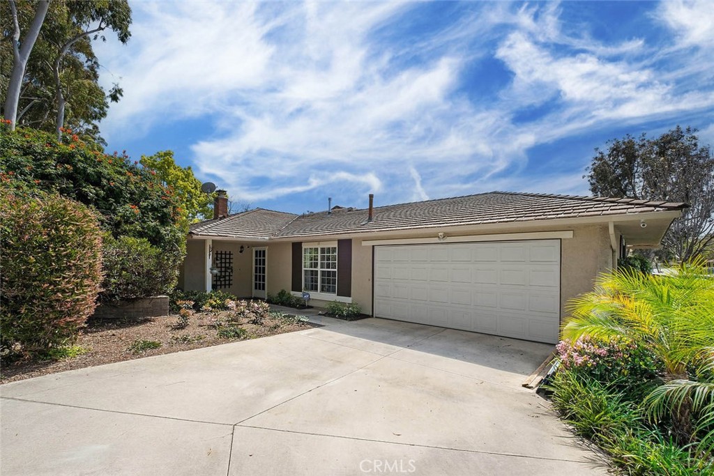 a view of a house with a bench and potted plants
