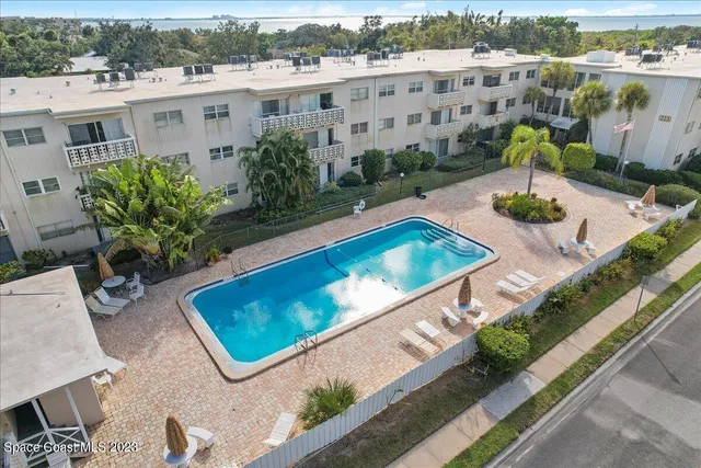 an aerial view of a city with lots of residential buildings ocean and mountain view in back