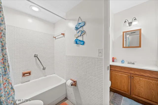 a living room with furniture ceiling fan and a large window