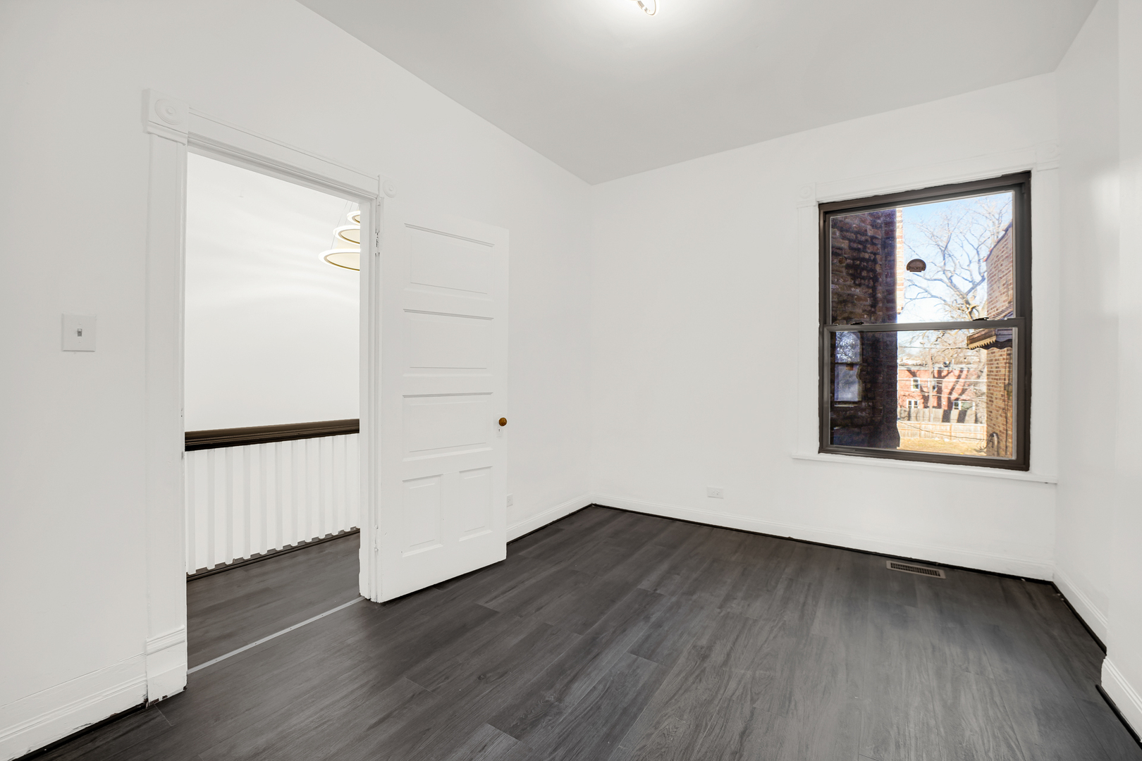 928 East 46th Street Chicago, IL 60653 - Photo 15 of 25 an empty room with wooden floor and windows