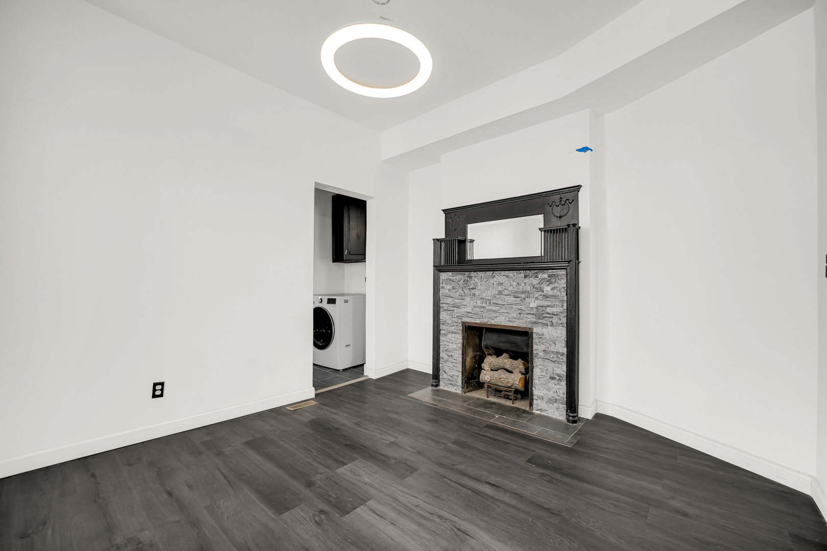 928 East 46th Street Chicago, IL 60653 - Photo 7 of 25 a view of an empty room with wooden floor and a fireplace