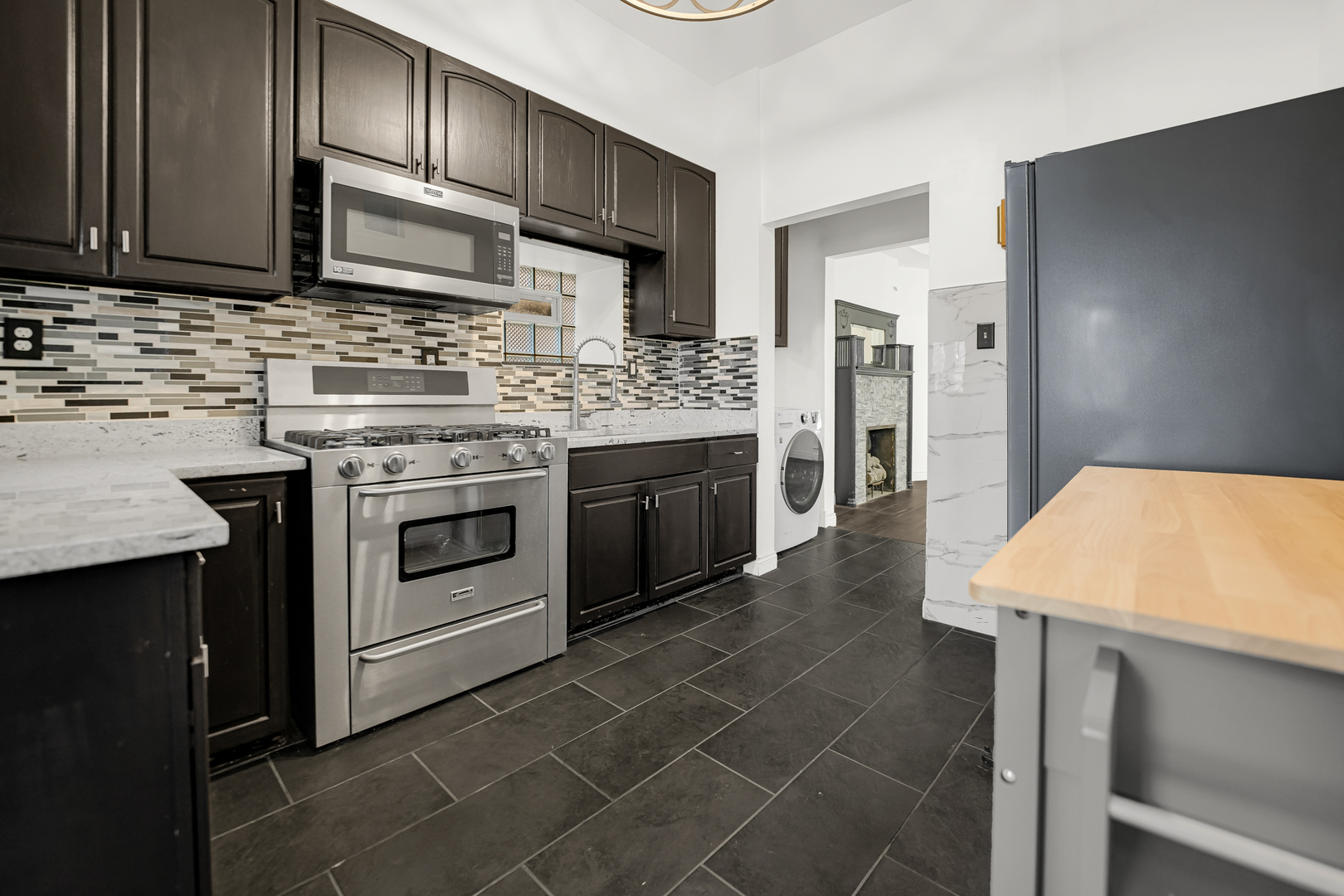 928 East 46th Street Chicago, IL 60653 - Photo 9 of 25 a kitchen with stainless steel appliances a stove a sink and a microwave