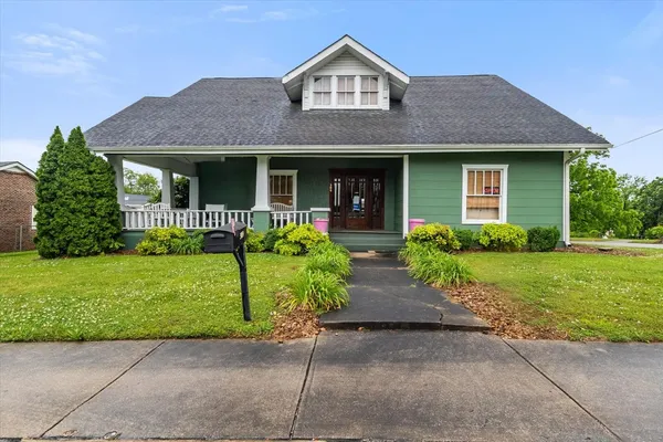 a front view of a house with a garden and plants