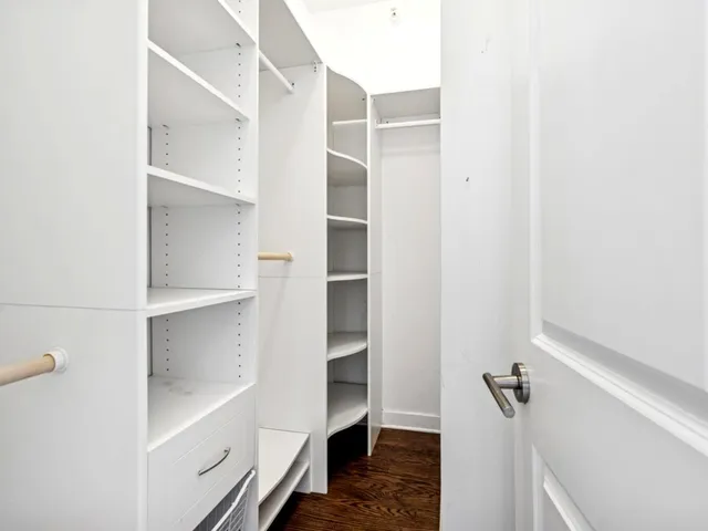 a view of walk in closet with empty racks