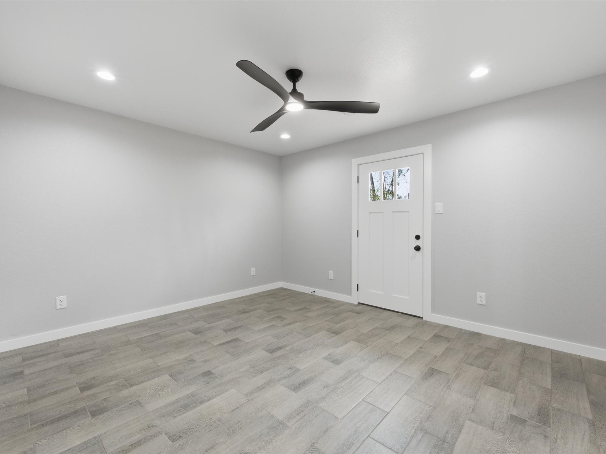 308 South 11th Street Conroe, TX 77301 - Photo 12 of 24 an empty room with wooden floor and a ceiling fan
