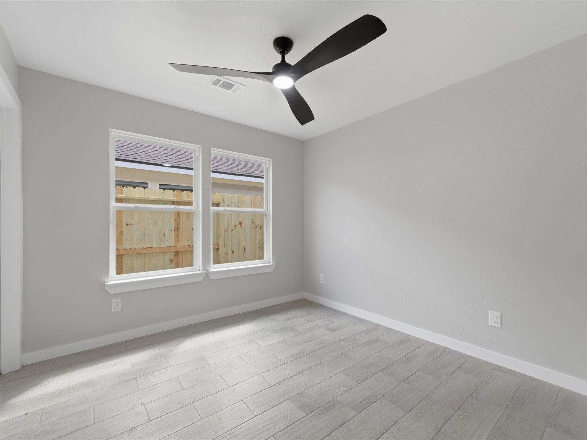 308 South 11th Street Conroe, TX 77301 - Photo 17 of 24 an empty room with ceiling fan and windows