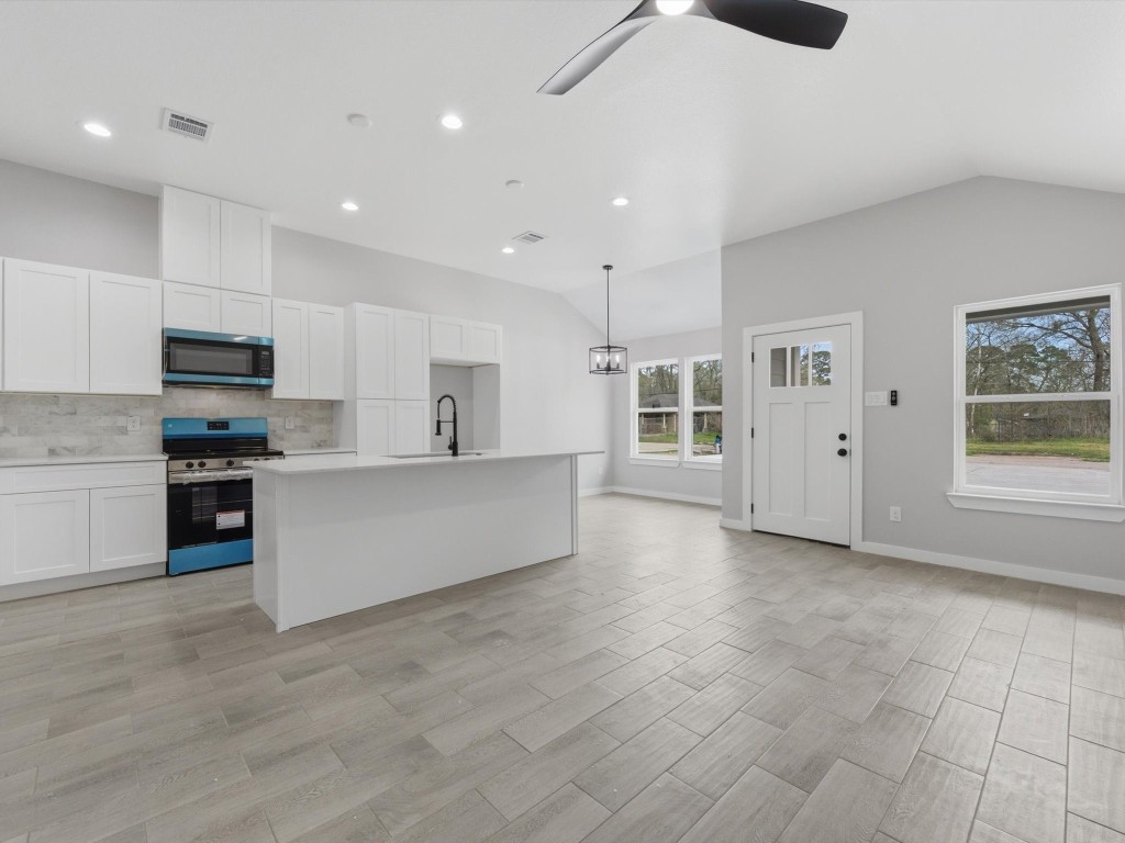 308 South 11th Street Conroe, TX 77301 - Photo 6 of 24 a large kitchen with stainless steel appliances a large counter top and a refrigerator