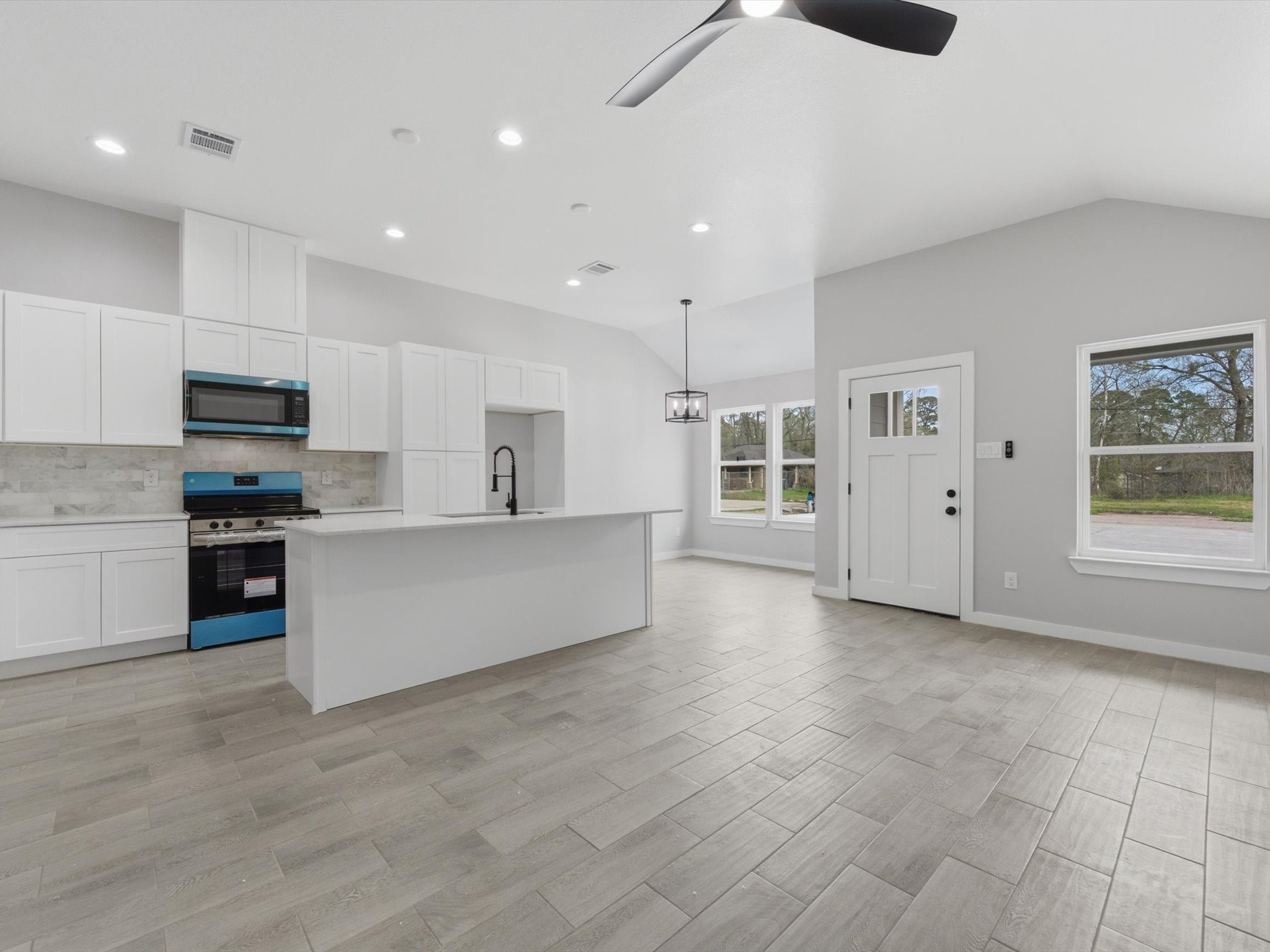 308 South 11th Street Conroe, TX 77301 - Photo 6 of 24 a large kitchen with stainless steel appliances a large counter top and a refrigerator