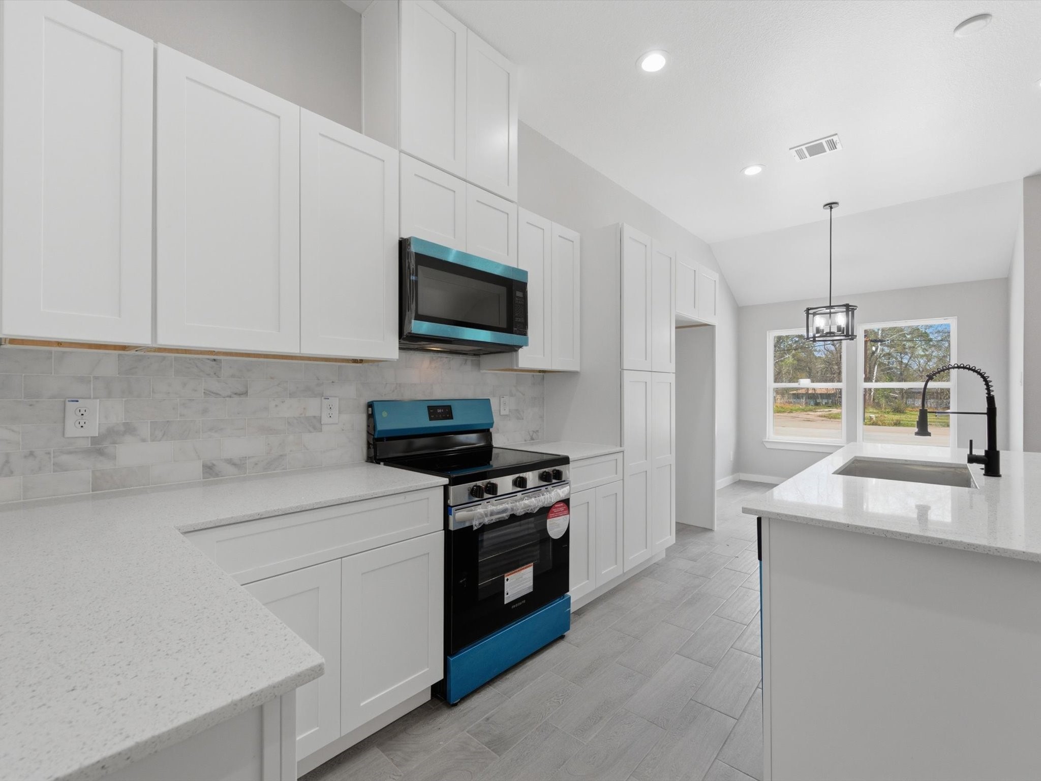 308 South 11th Street Conroe, TX 77301 - Photo 7 of 24 a kitchen with a sink a stove and microwave