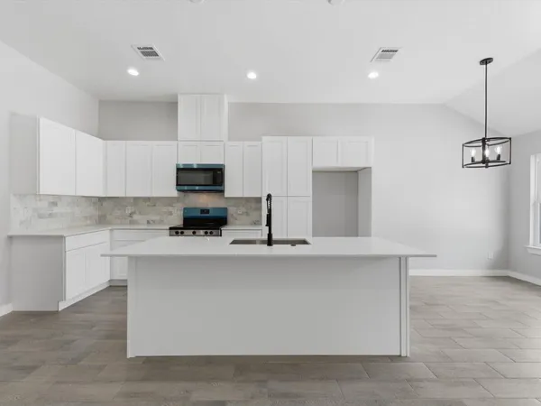 a kitchen with a sink a stove and microwave