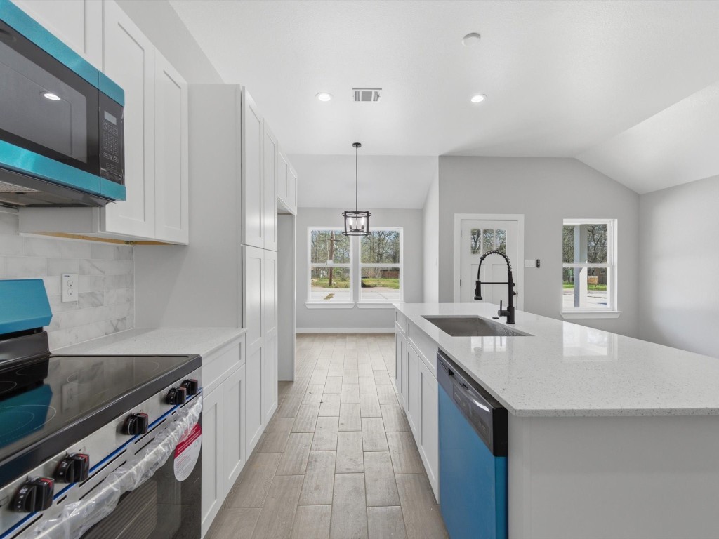 308 South 11th Street Conroe, TX 77301 - Photo 9 of 24 a kitchen with stainless steel appliances a sink stove and cabinets