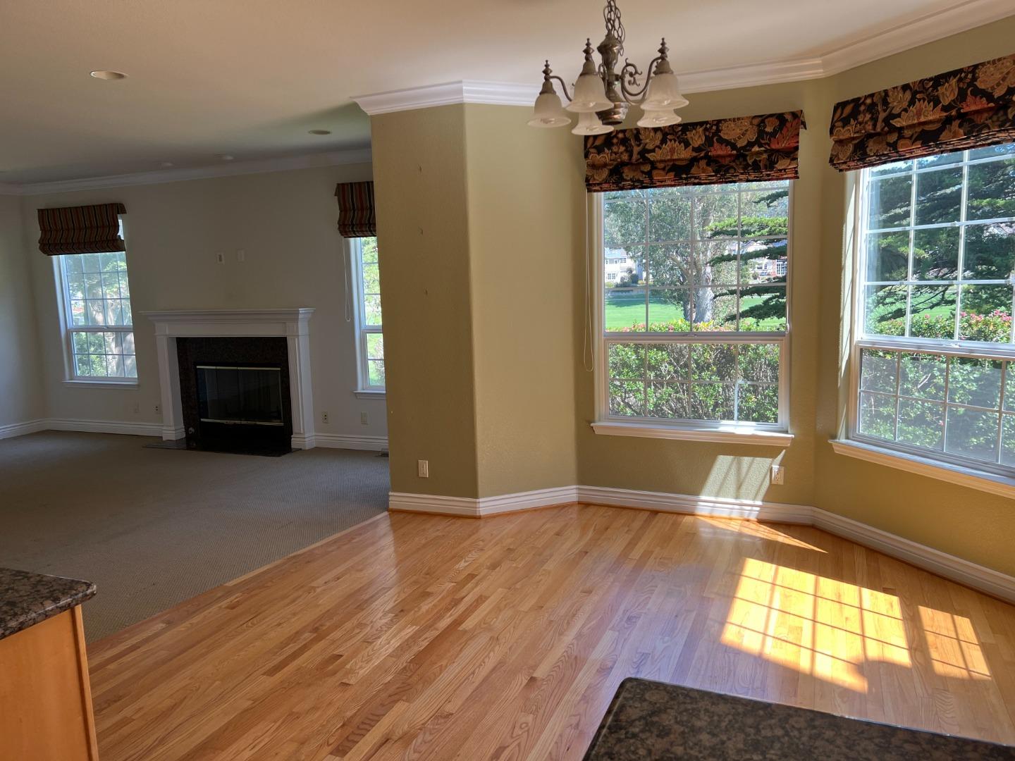 61 Turnberry Road Half Moon Bay, CA 94019 - Photo 3 of 6 an empty room with wooden floor a fireplace and windows