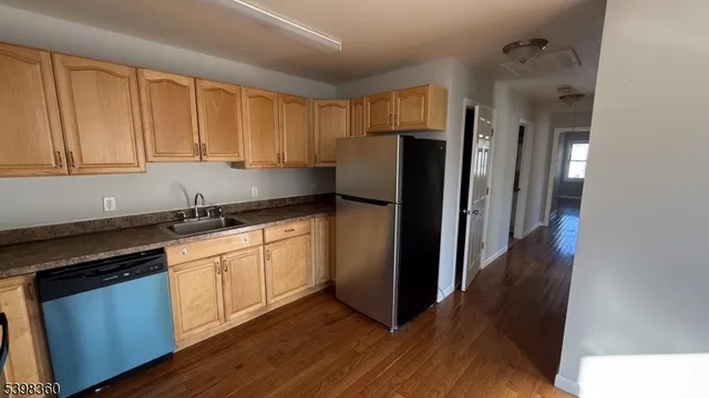 a kitchen with granite countertop a refrigerator stove and sink
