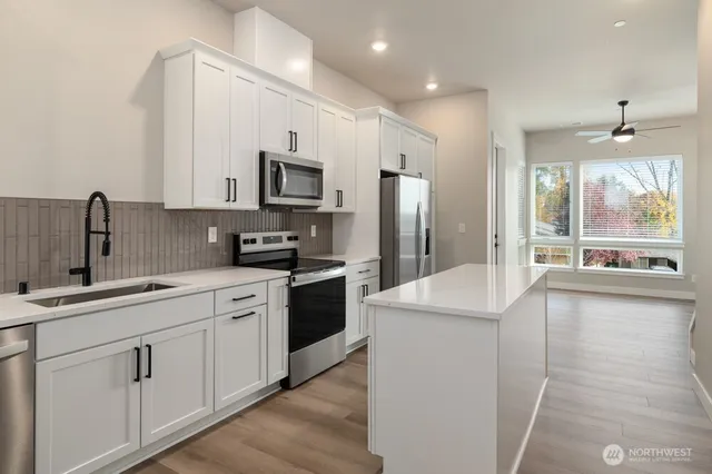 a kitchen with stainless steel appliances sink stove refrigerator and cabinets