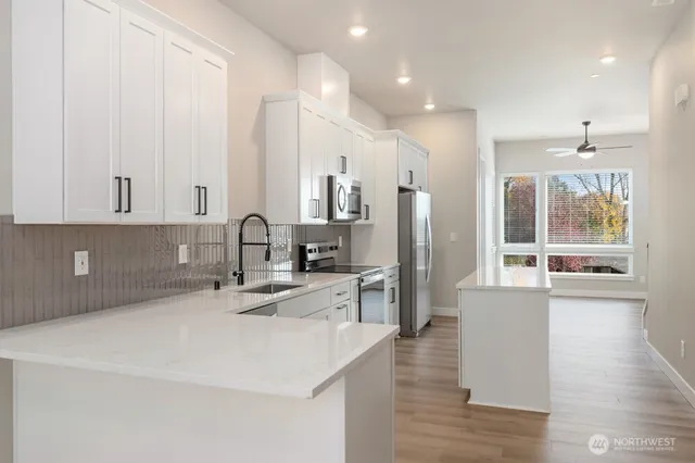 a kitchen with stainless steel appliances granite countertop a sink a stove and a refrigerator