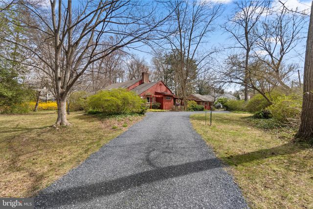 a yellow house with flower garden in front of it