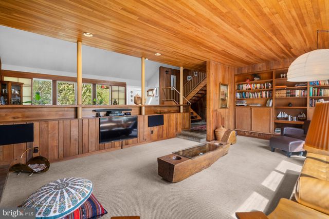 a dining room with wooden floor and windows