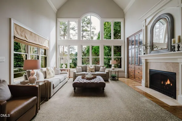 a living room with fireplace furniture and a large window